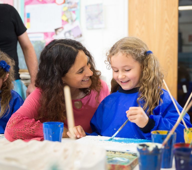 student painting with her teacher