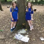 2 girls next to a tree