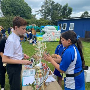 students talking at a fete shop