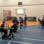 students in a hall with tables