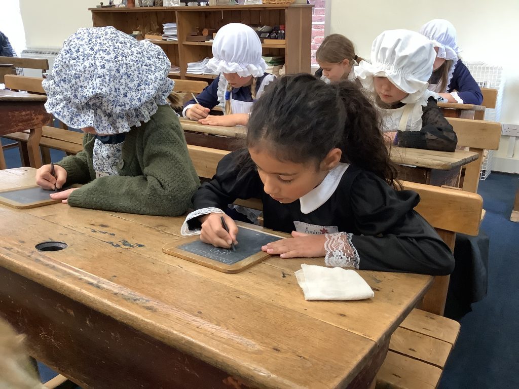 students writing on mini chalkboards