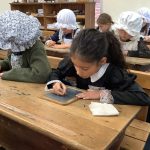 students writing on mini chalkboards