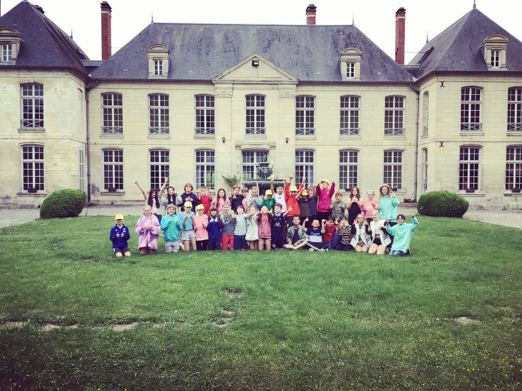 Students outside a large manor building