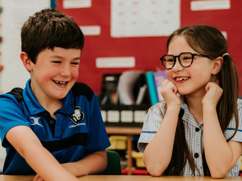 Two children in class having fun and laughing together