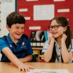 Two children in class having fun and laughing together