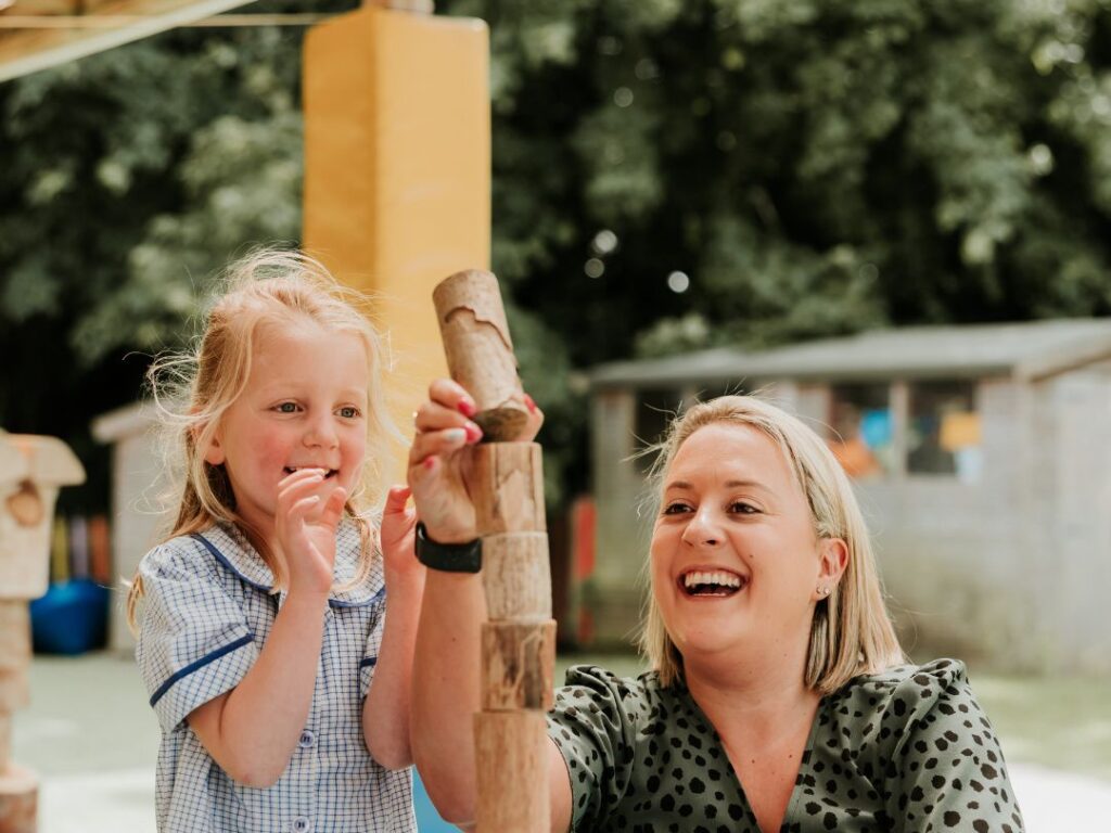 Educator and child playing together outside