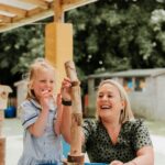 Educator and child playing together outside