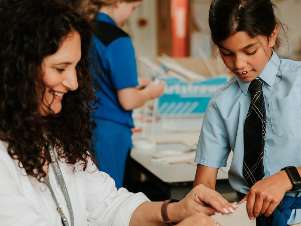 Teacher helping pupil in Art & DT lesson