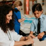 Teacher helping pupil in Art & DT lesson