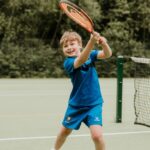 Young boy playing tennis at Longacre School